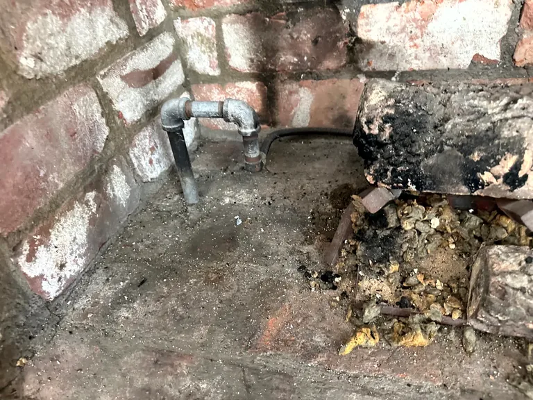 Fire damaged brick fireplace and debris