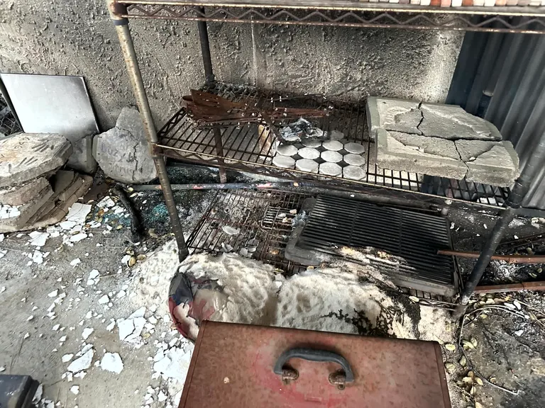 Fire damaged outdoor grill and debris