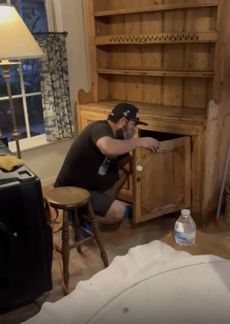 Technician cleaning exposed built in shelving