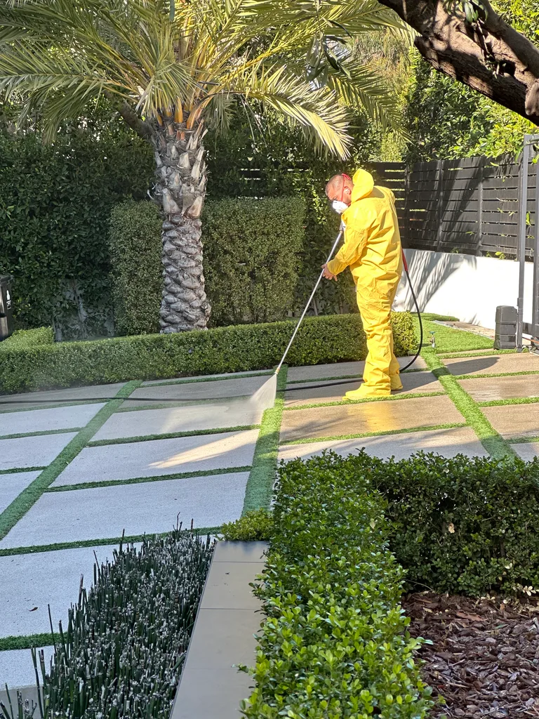 Technician pressure washing outdoor paving